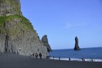 Der schwarze Sandstrand Dyrh�laey mit Menschen die auf grauen Basals�ulen klettern